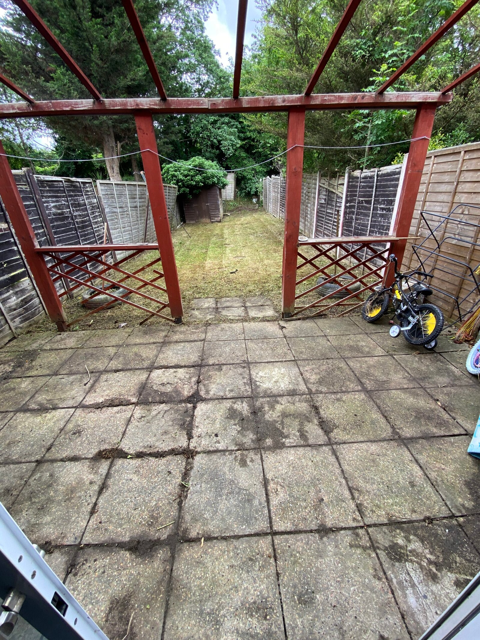Paved garden area cleared of overgrown vegetation