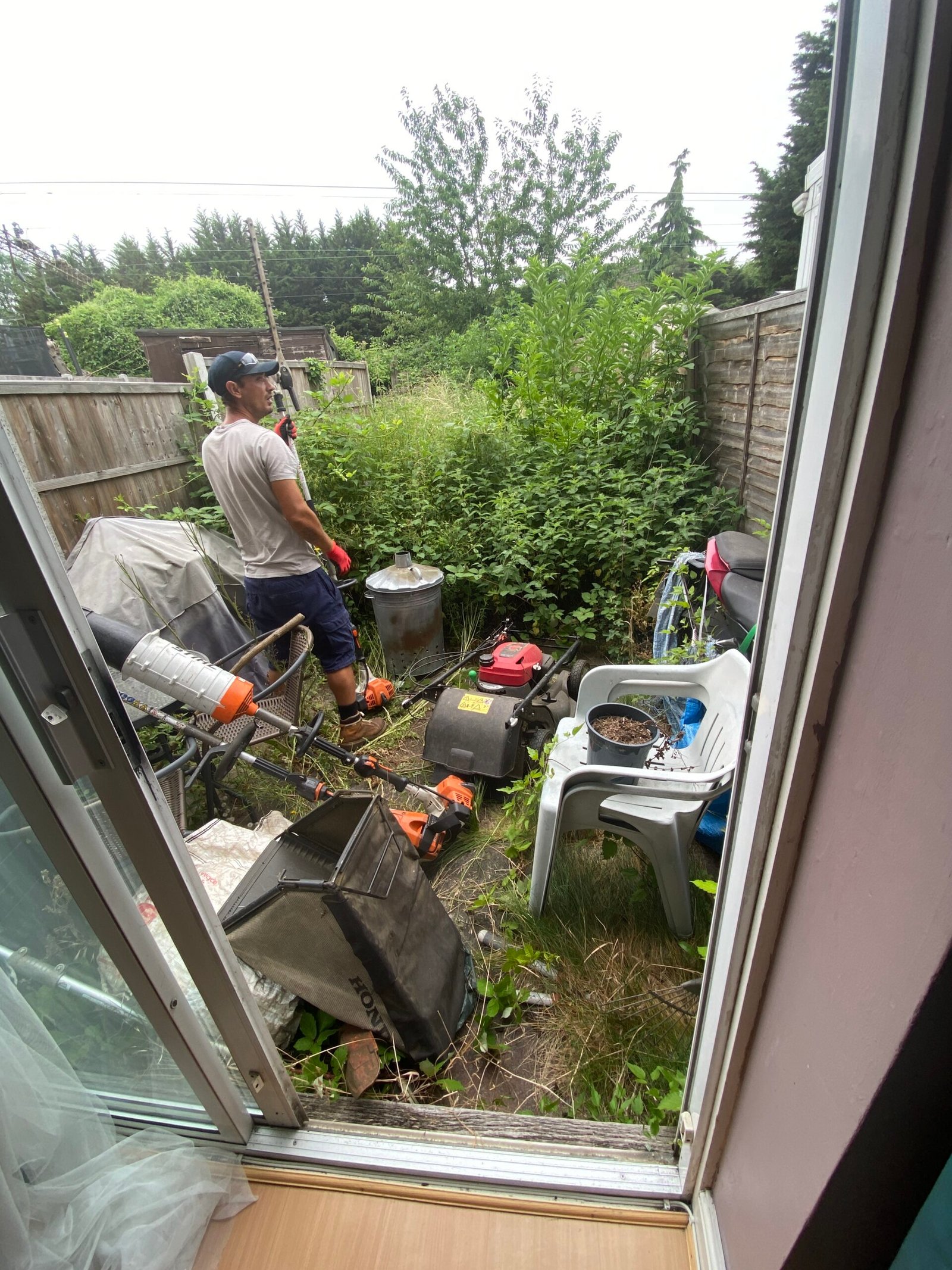 luttered garden with unwanted items before clearance