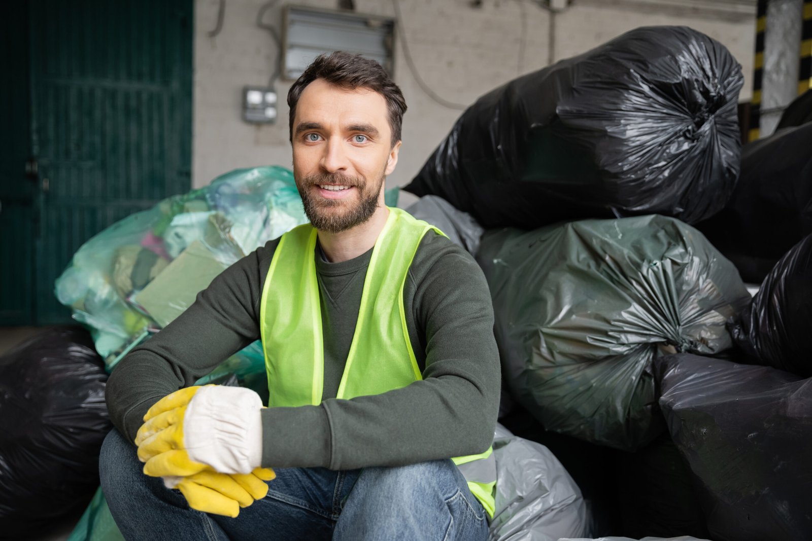 Rubbish removal worker with bags of household waste