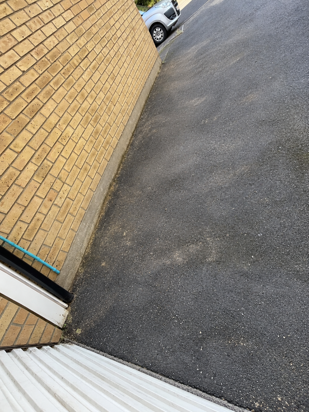 garden clearance weed free tarmac driveway beside brick wall