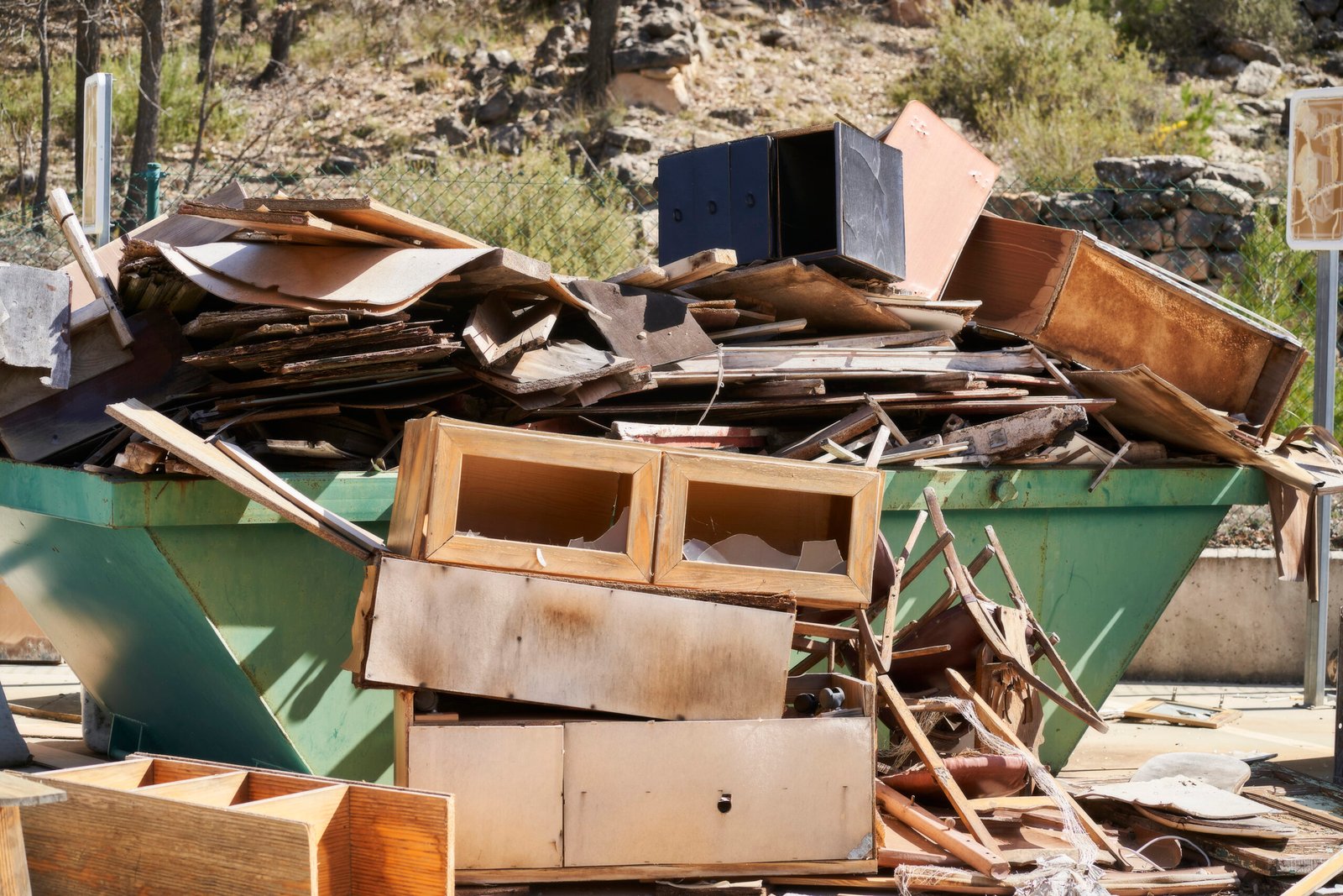 house clearance services skip filled with old wooden furniture and boards